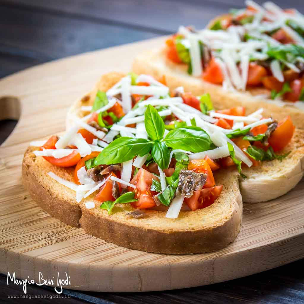 Bruschette sfiziose con pomodorini, acciughe, pecorino e basilico