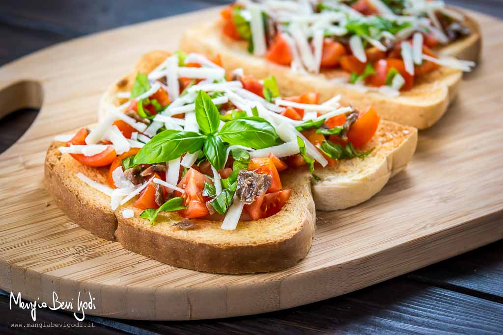 Bruschette sfiziose con pomodorini, basilico,acciughe e pecorino