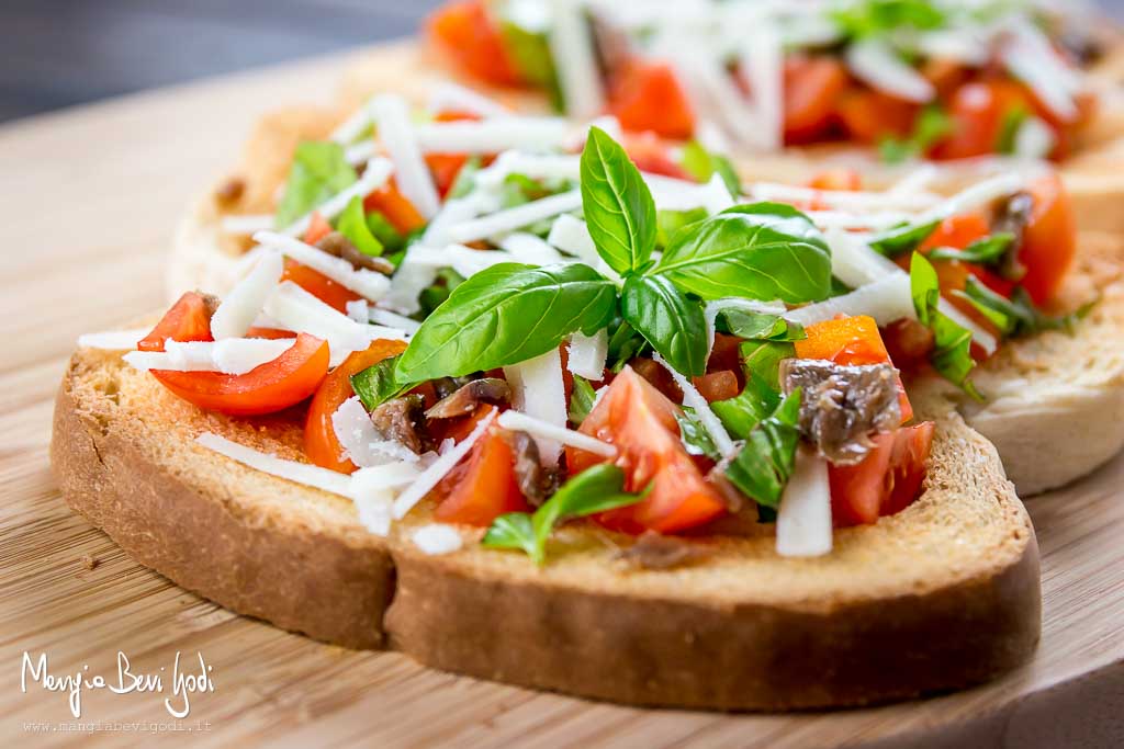 Bruschette sfiziose con pomodorini, basilico,acciughe e pecorino