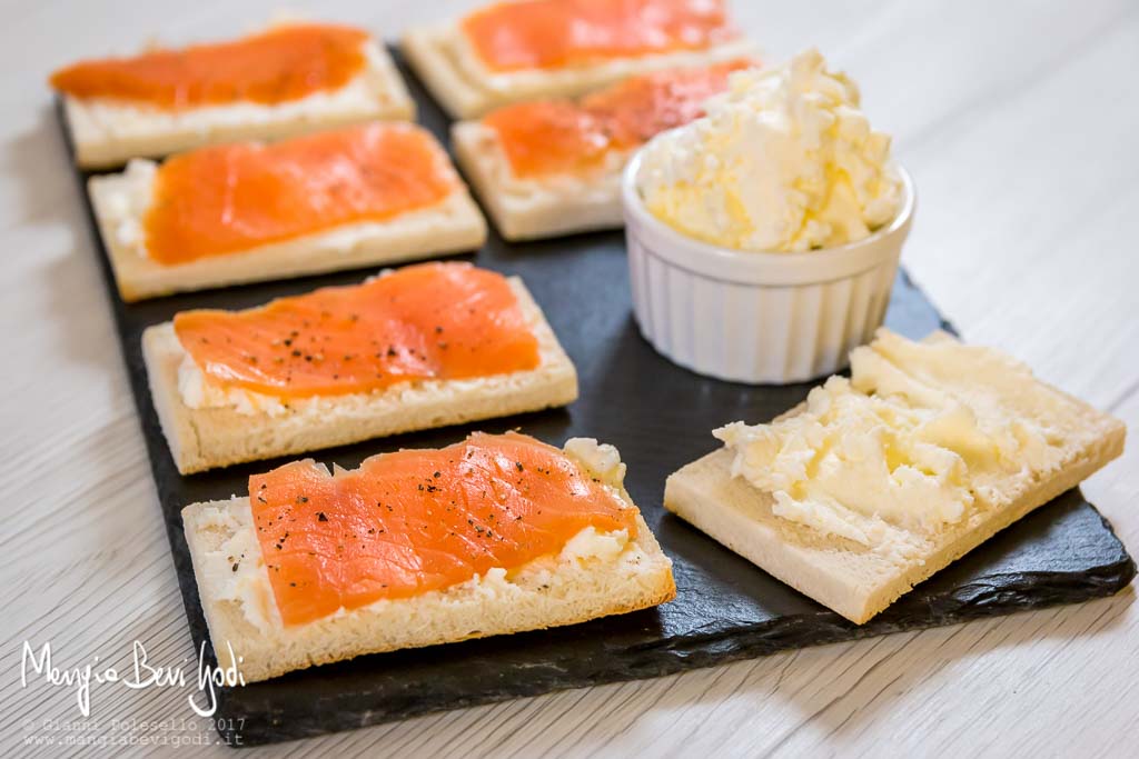 Crostini con salmone serviti su piatto di ardesia 