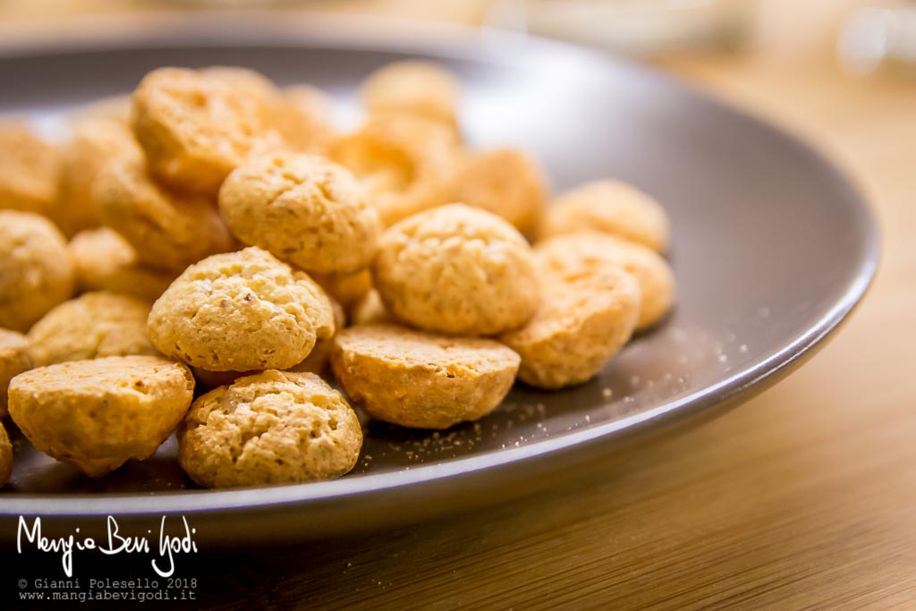 Piccoli amaretti su piatto marrone da utilizzare per guarnire il tiramisù al bicchiere