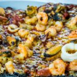 Pizza al nero di seppia con frutti di mare