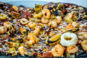 Pizza al nero di seppia con frutti di mare