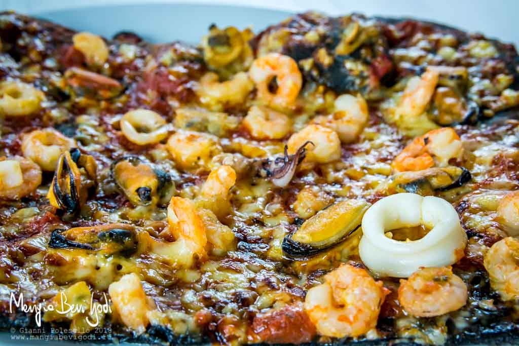 Pizza al nero di seppia con frutti di mare