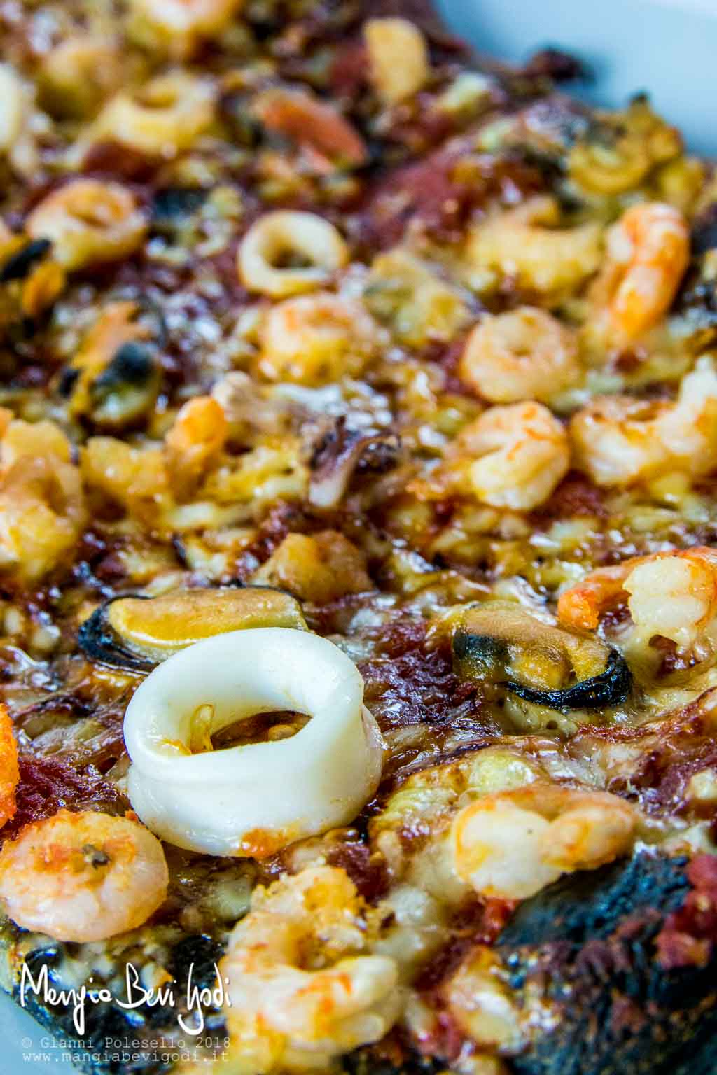 Pizza al nero di seppia con frutti di mare