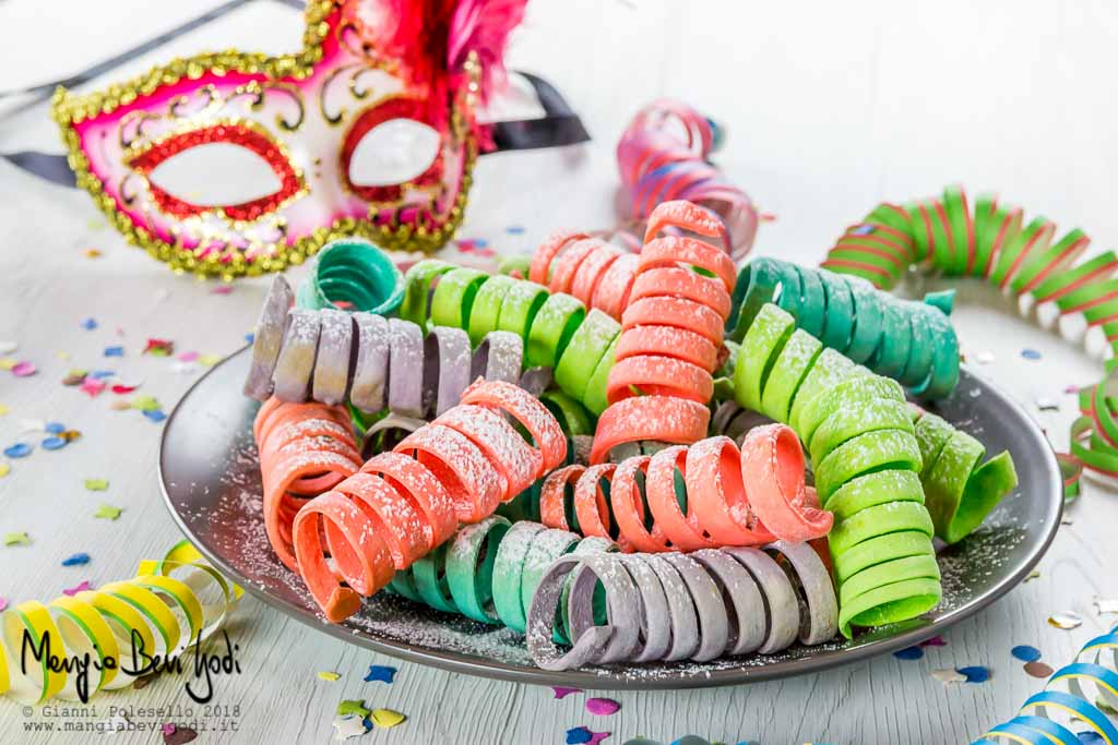 Stelle filanti dolci e colorate con maschera di Carnevale veneziana sullo sfondo