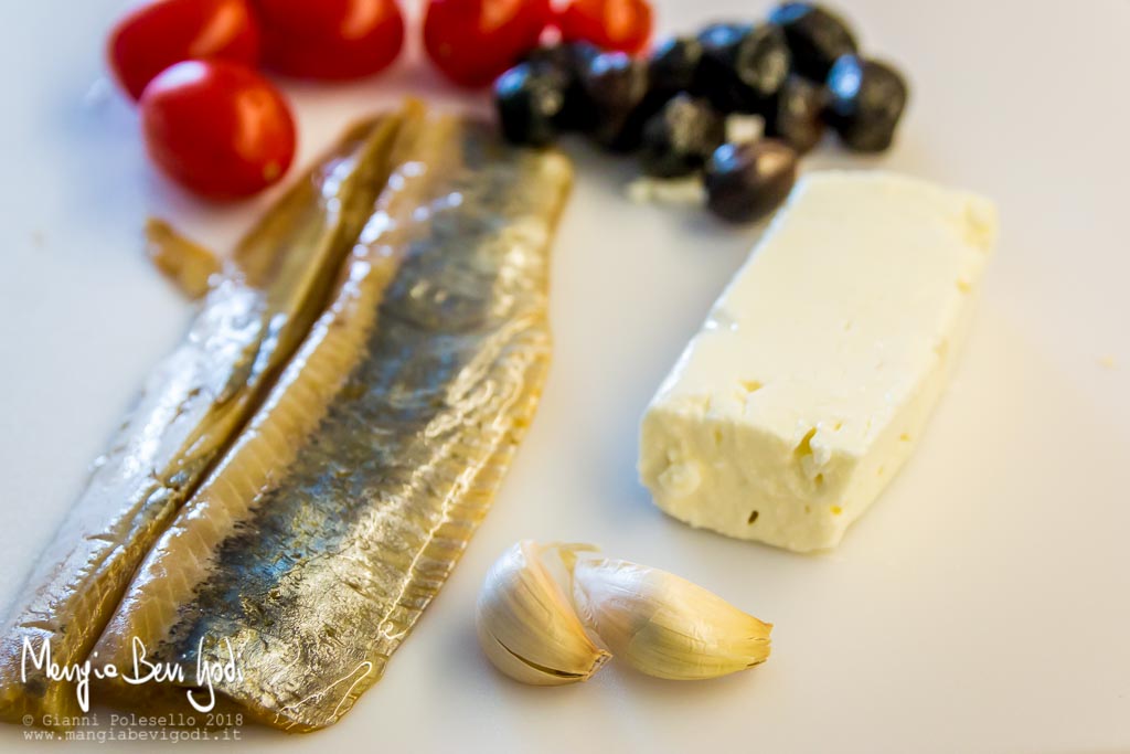 Gli ingredienti: filetti di aringa, aglio, feta greca, olive nere, pomodorini