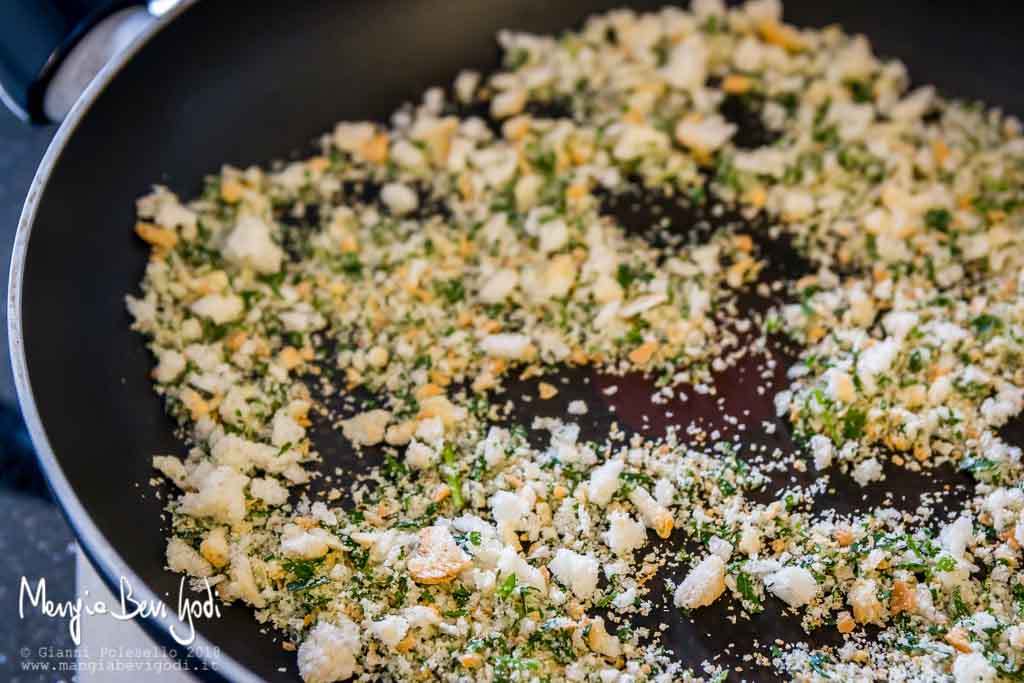 Tostatura mollica aromatizzata con aglio e prezzemolo in una padella antiaderente