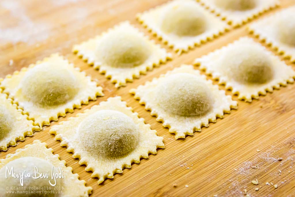 Agnolotti ripieni di salsiccia sopra spianatoia di legno