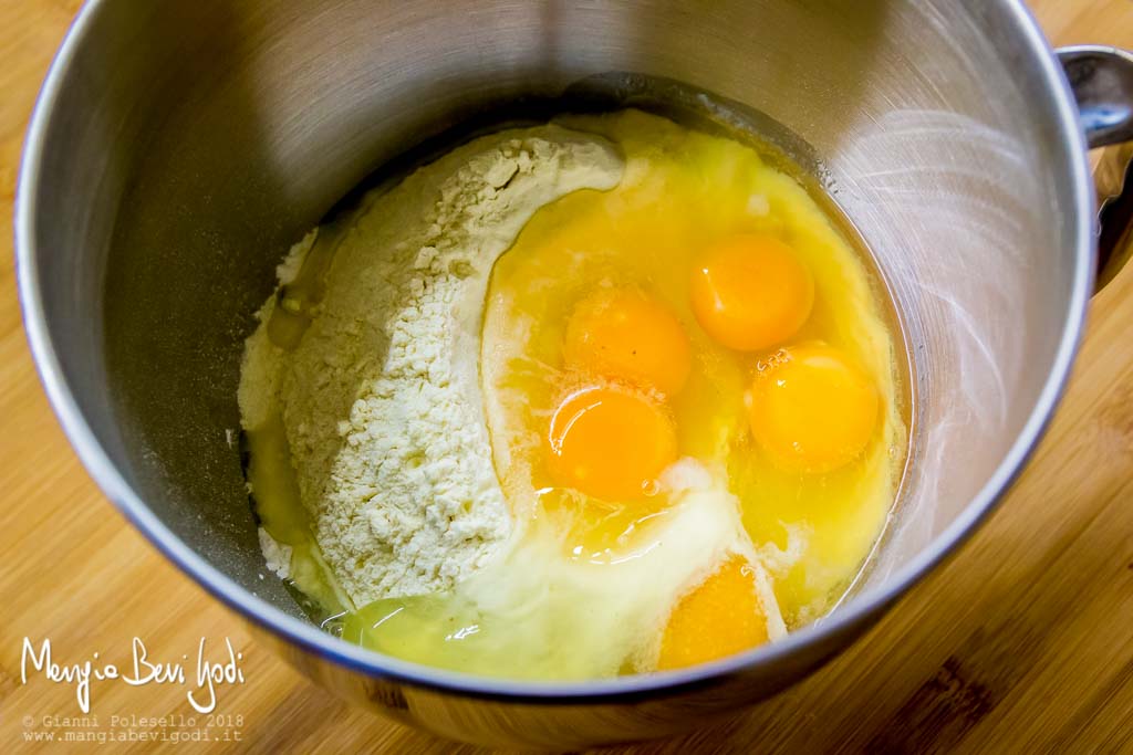 Ingredienti della pasta fresca in ciotola metallica (uova, farina, semola di grano duro)