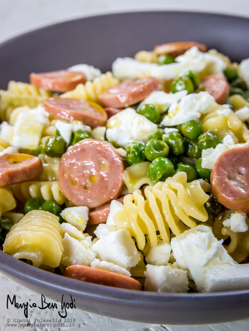 Radiatori con wurstel, feta e piselli