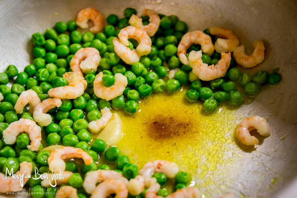 Preparazione sugo di piselli e gamberetti in padella di alluminio