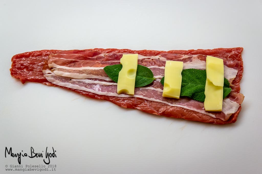 Ricoprire le fettine di carne con pancetta, salvia e emmental