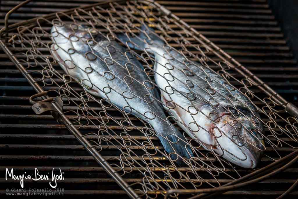 Orate racchiuse in una graticola per pesce cotte in un barbecue a gas