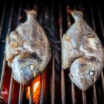 Cottura di due orate nella griglia del barbecue