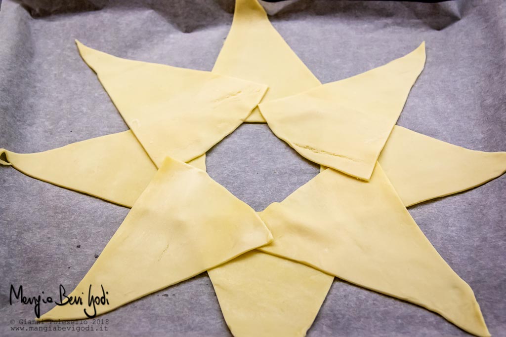 Posizionare i triangoli di pasta sfoglia a formare una stella con il buco al centro