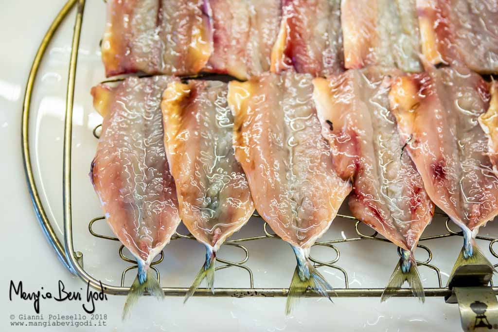 Pesce azzurro di piccola taglia disposto su una graticola di marca weber