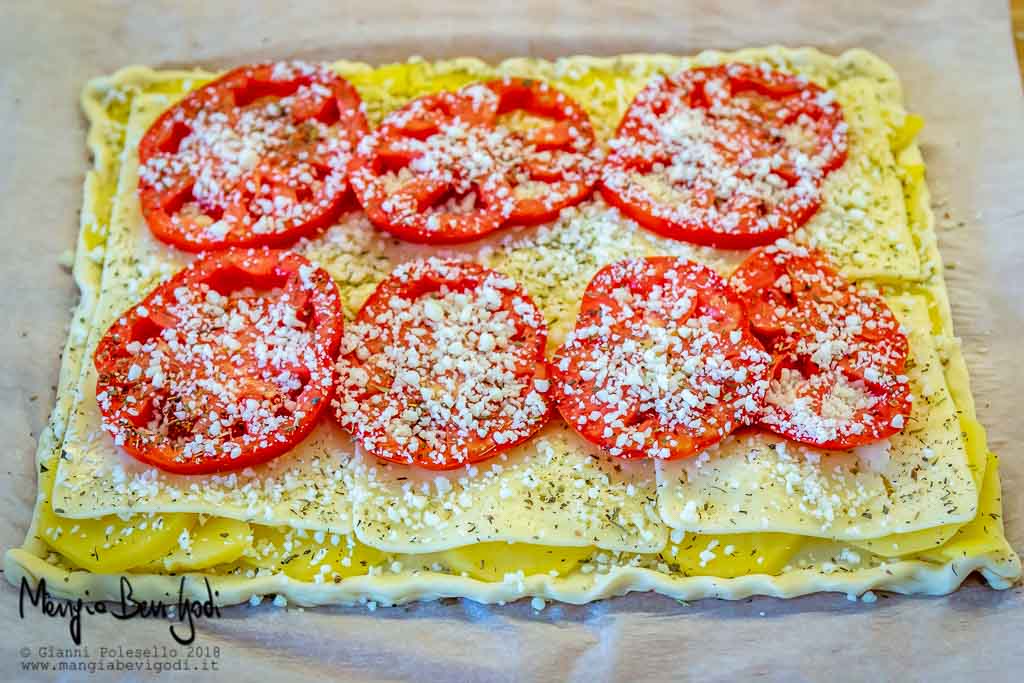 Infornare la torta salata con pomodori, patate e formaggio