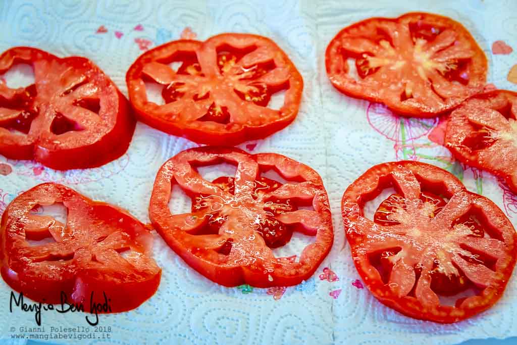 Fettine di pomodoro salate stese sopra carta assorbente