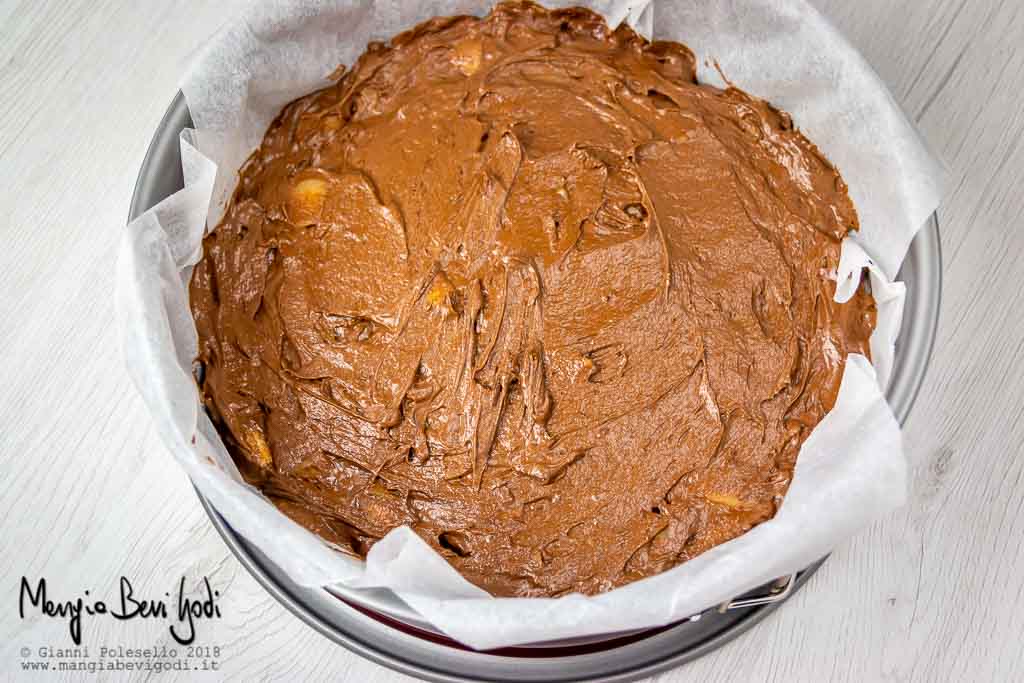 Tortiera foderata di carta da forno con all'interno l'impasto per la torta pere e cioccolato