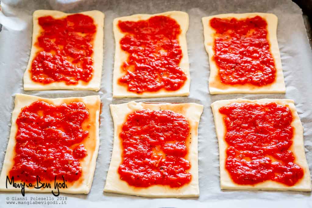 Farcire le pizzette con la polpa di pomodoro e l'origano