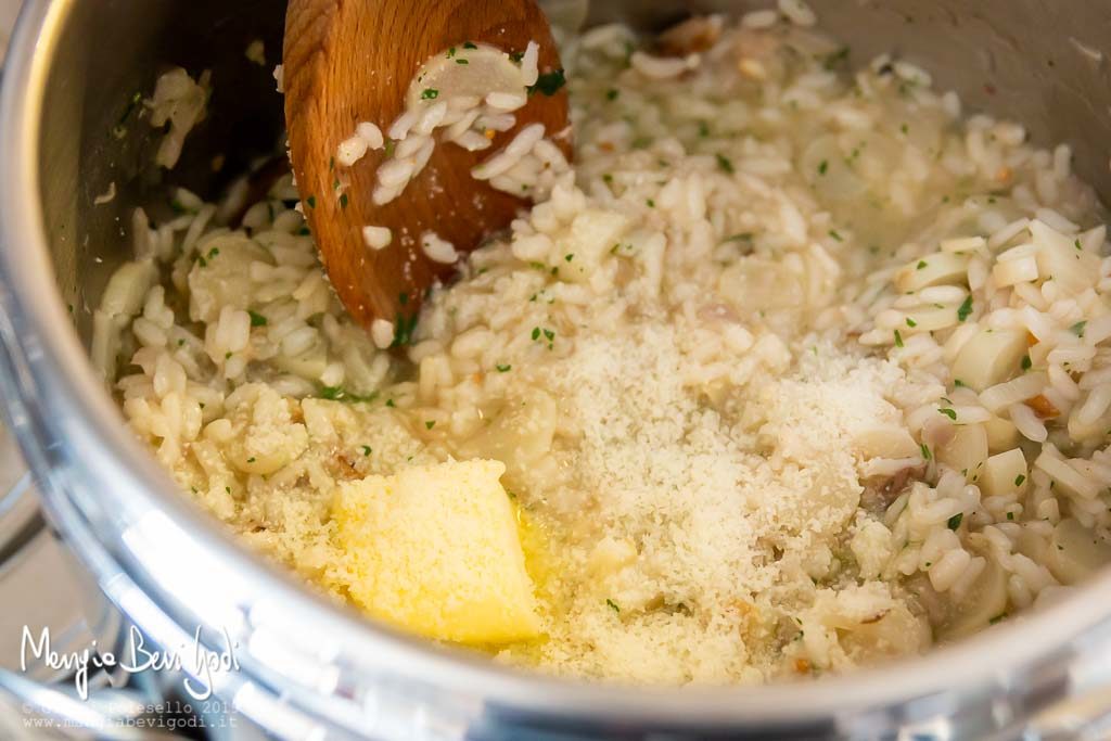 Mantecare il risotto agli asparagi e sgombro affumicato con burro, prezzemolo e parmigiano.