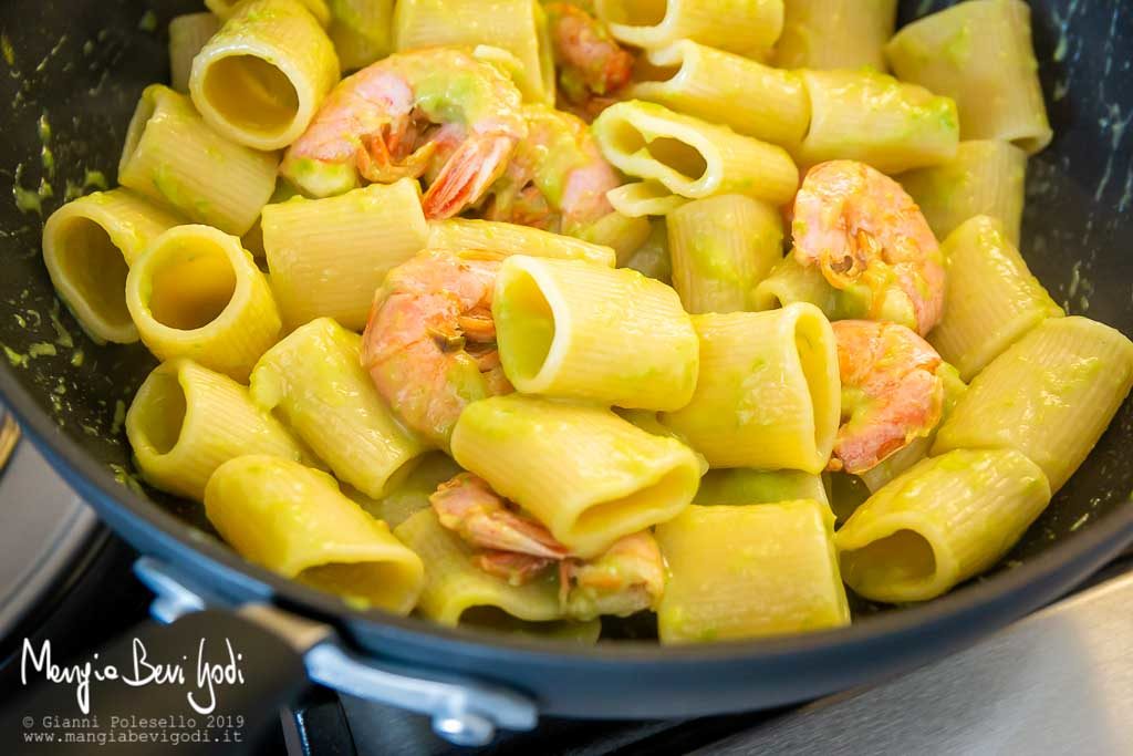 wok antiaderente con dentro paccheri e sugo di asparagi e gamberoni