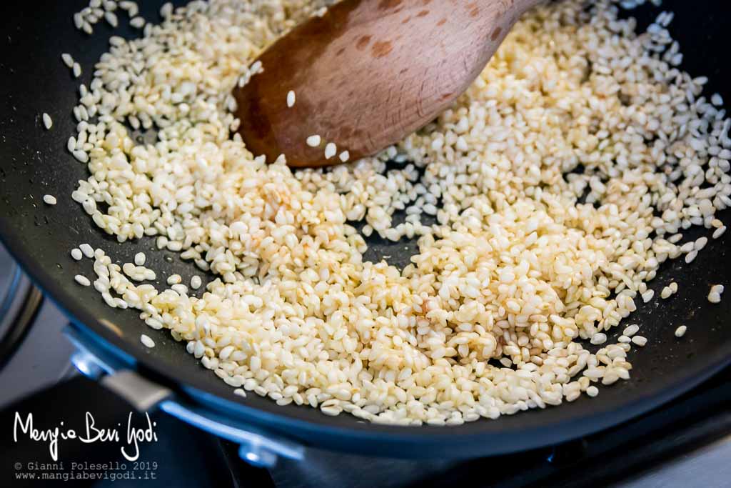 Fase di tostatura del riso in un wok