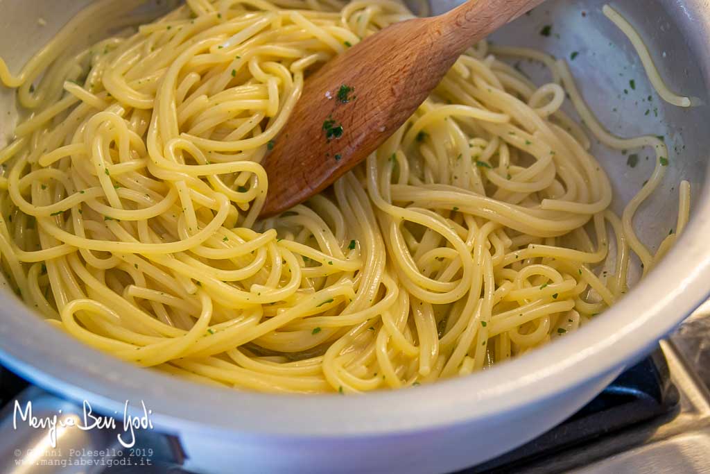 Cottura degli spaghetti con le cape tonde in una padella di alluminio con la tecnica della pasta risottata