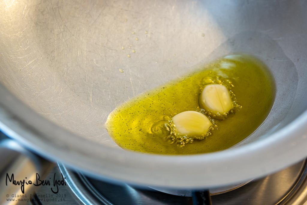 Spicchio d'aglio che soffrigge in padella di alluminio