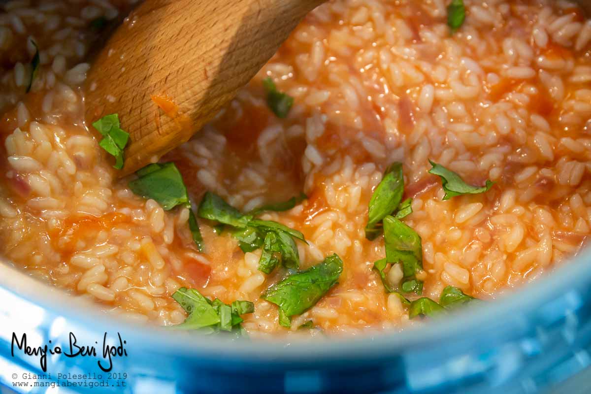 Preparazione risotto con pomodoro e basilico