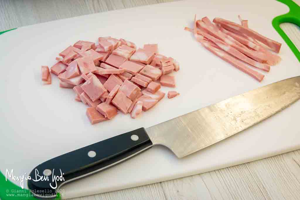 Tagliare una fetta di mortadella a cubetti