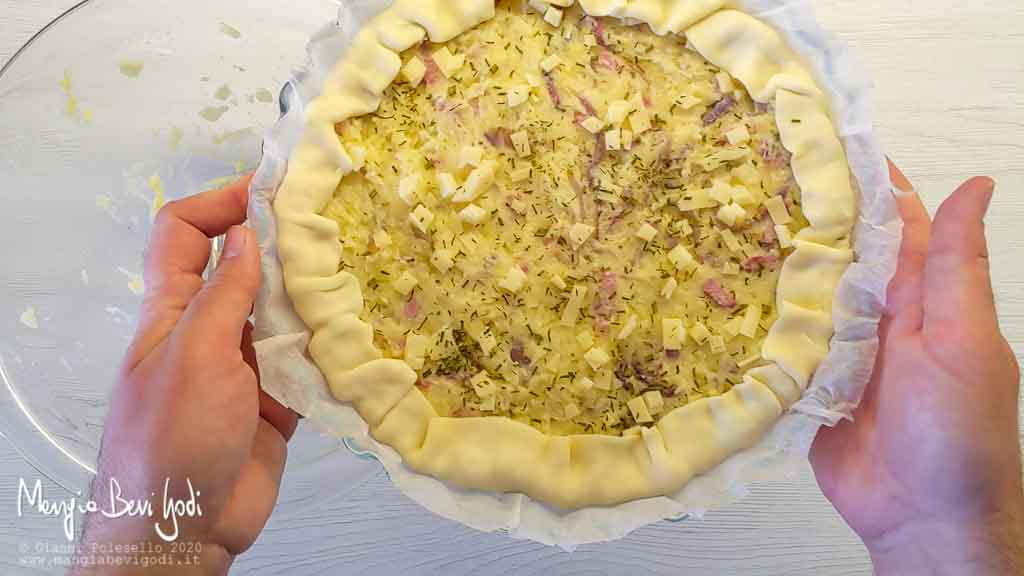 Preparazione torta salata con patate cipolle pancetta e formaggio