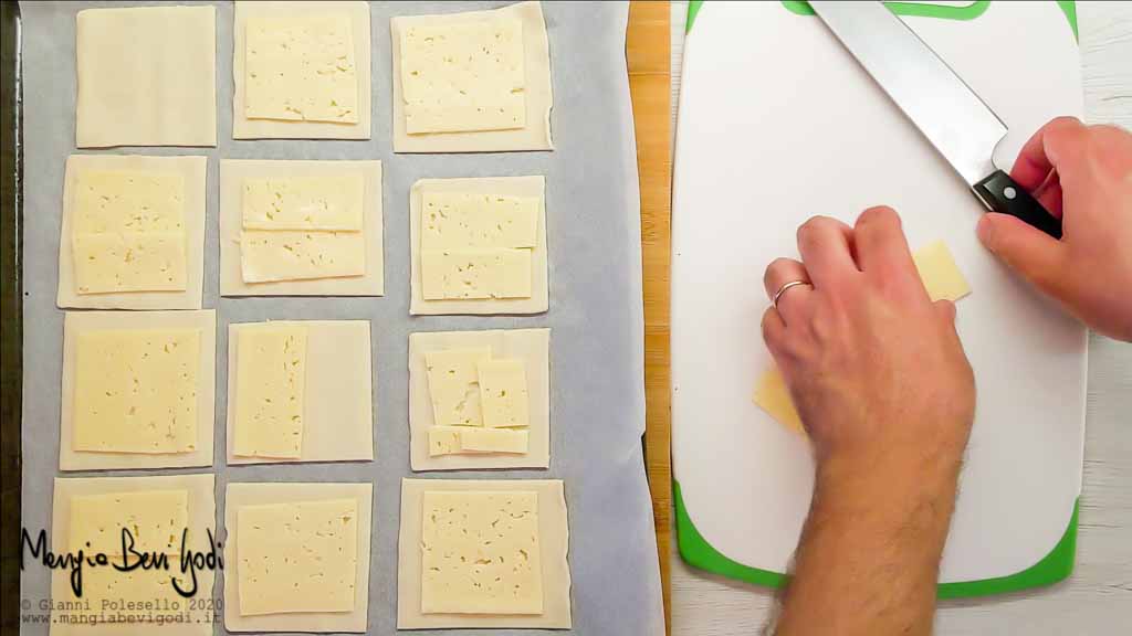 Disporre il formaggio sopra i quadrati di pasta sfoglia