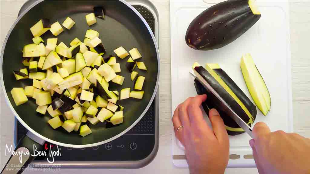 Tagliare a cubetti e cuocere le melanzane in padella