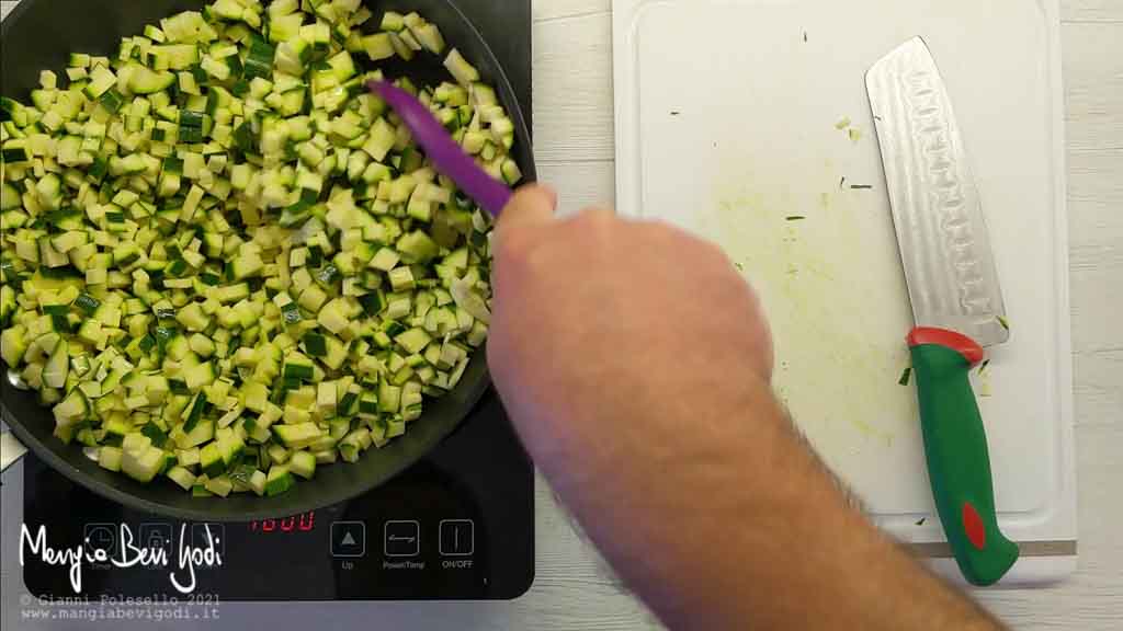 Tagliare a cubetti e cuocere le zucchine in padella