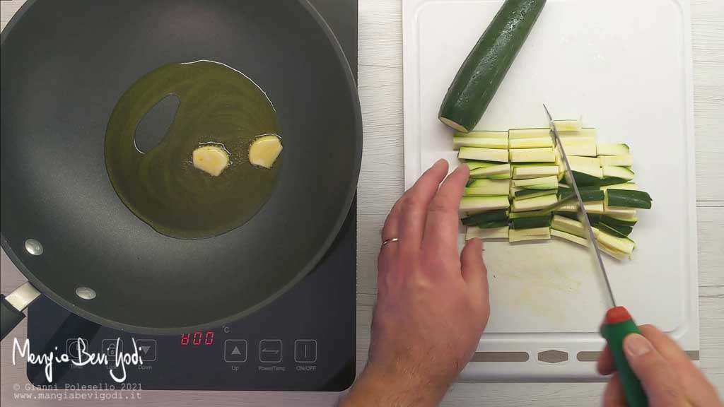 Soffriggere l'aglio e tagliare le zucchine