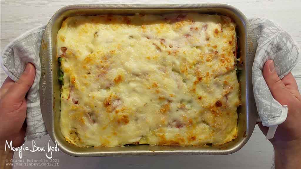 Preparazione lasagne con prosciutto e piselli