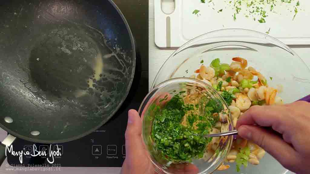Condire l'insalata di gamberi, cannellini, sedano e arachidi