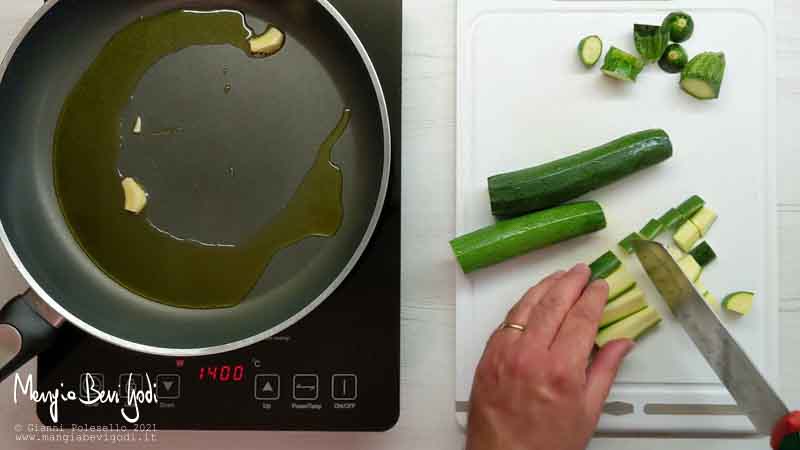 Soffriggere l'aglio e tagliare le zucchine