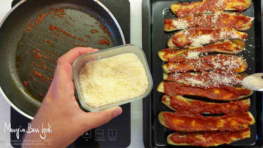 Ricoprire le melanzane con provola, pomodoro, parmigiano e pangrattato