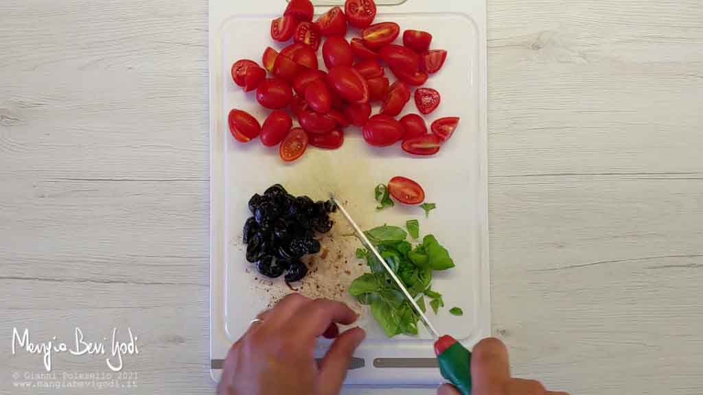 Tagliare pomodorini, basilico e olive nere