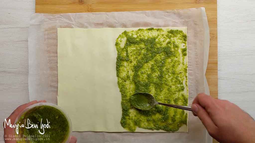 stendere un rotolo di pasta sfoglia e aggiungere il pesto