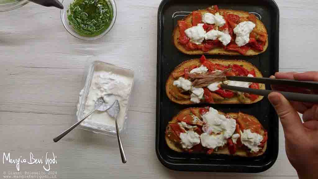 Preparazione bruschette con peperoni acciughe e stracciatella